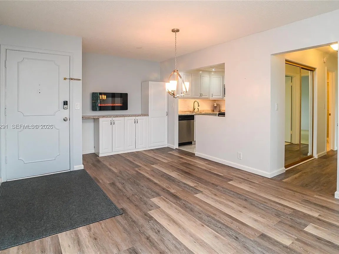 Unit as it is today: open living and dining area with updated kitchen